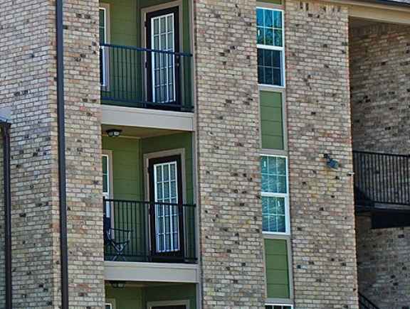 A green building with balconies and windows.