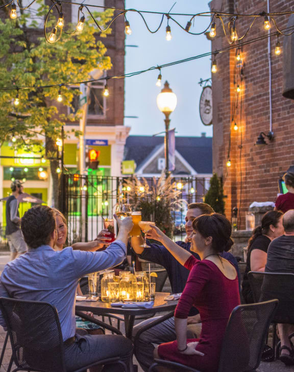 a group of people sitting at tables outside of a restaurant