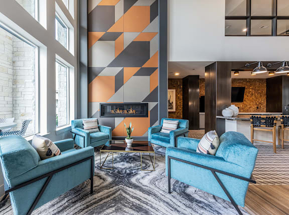 A living room with blue chairs and a fireplace.