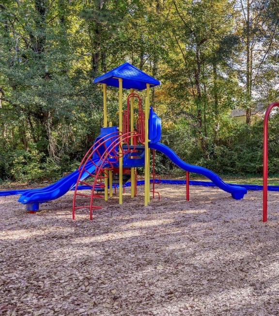 a playground with a blue and red swing set