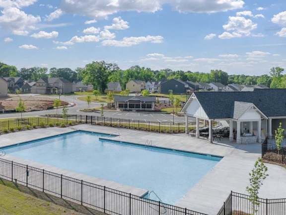 an aerial view of a swimming pool with houses in the background