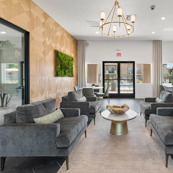 A living room with grey couches and a gold coffee table.
