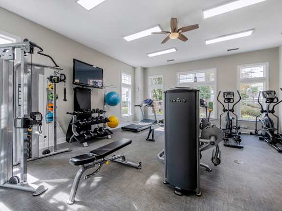 A spacious home gym with a variety of equipment including a treadmill, stationary bike, and weight machines.