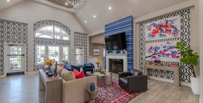 A living room with a fireplace and a large rug.