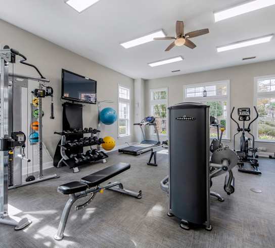 A spacious home gym with a variety of equipment including a treadmill, stationary bike, and weight machines.