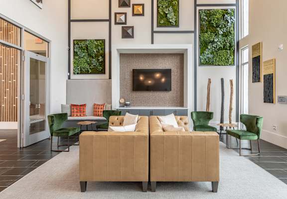 A living room with a tan couch and a fireplace.