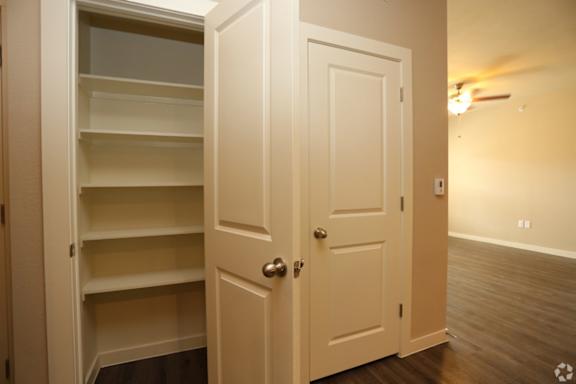 A white door with a shelf underneath it.