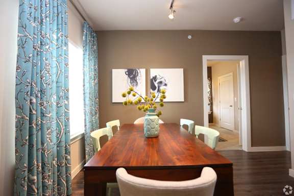 A dining room with a wooden table and chairs.