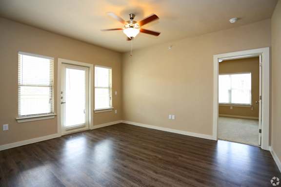 A room with a ceiling fan and wooden floors.
