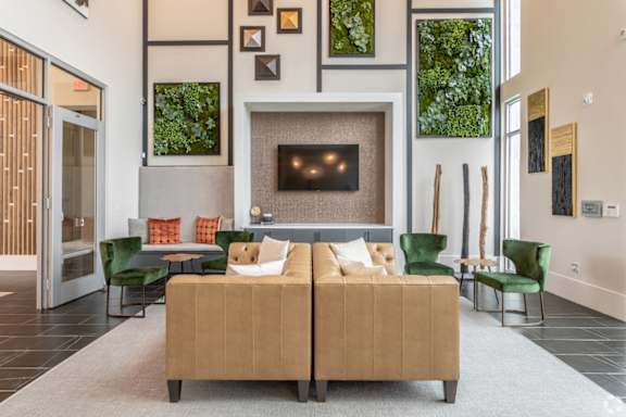 A living room with a tan couch and a fireplace.