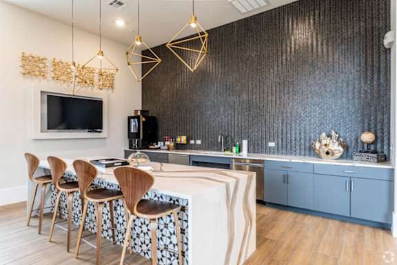 A modern kitchen with a bar area and chairs.