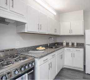 a kitchen with white cabinets and stainless steel appliances