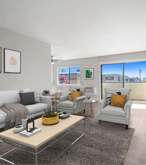 A living room with a grey couch, a yellow vase, and a glass coffee table.