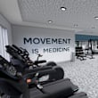 A gym with a sign that says "MOVEMENT IS MEDICINE".