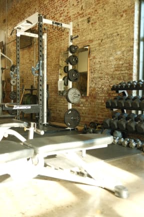a gym with weights and a bench in it