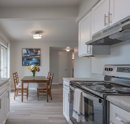 A kitchen with a table and chairs in the middle.