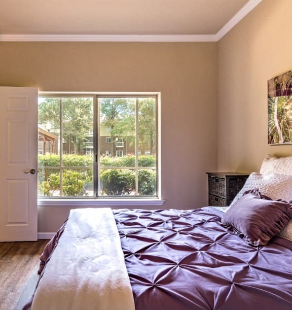 a bedroom with a bed and a large window