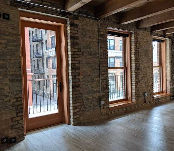 A room with wooden floors and brick walls.