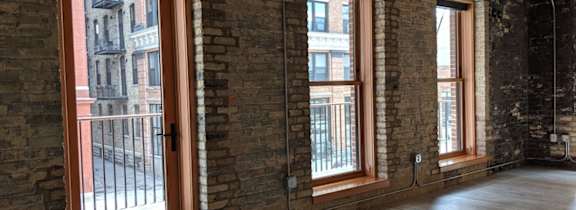 A room with wooden floors and brick walls.