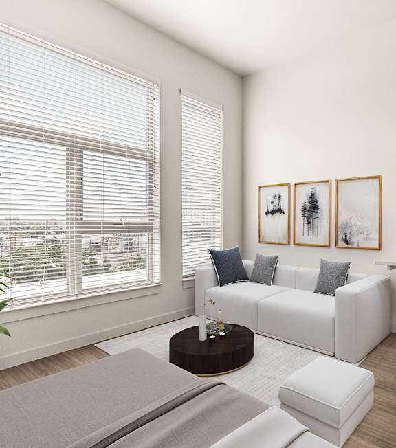 A modern living room with a white sofa, a coffee table, and a kitchen area in the background. at RiDE at RiNo Apartments, Colorado