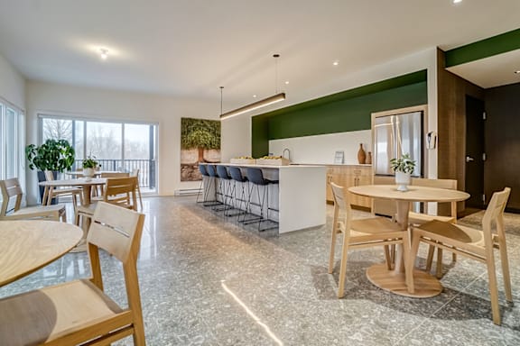 A modern living room with a large sectional sofa and a green armchair. at Champlain Village Urbain Apartments , Gatineau