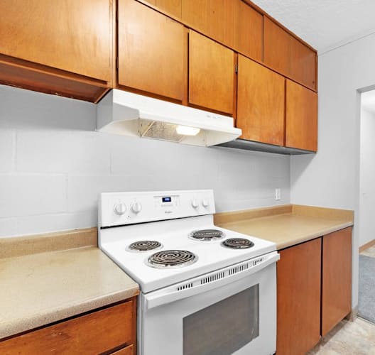 a kitchen with a stove and cabinets and a white oven