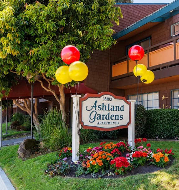 the sign for the ashland gardens apartments is shown in front of a flag