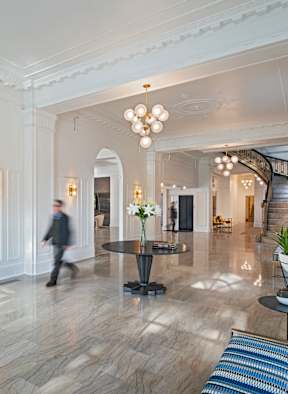 A Detroit City storefront with a black awning and glass doors.