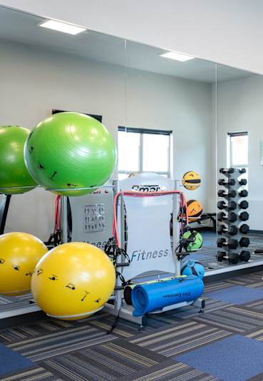 Apartments for Rent in Oregon City, OR - Timberview - Fitness Center with Exercise Balls, Free Weights, Mirror Wall, Strength Training Machine, Treadmill, and Elliptical Machine.