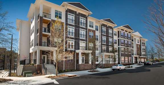 an exterior view of an apartment building on a snowy street