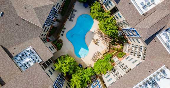 an overhead view of a pool in the middle of an apartment building