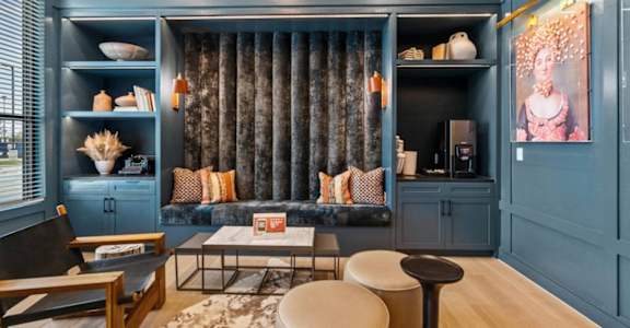 a living room with blue walls and a couch and blue cabinets