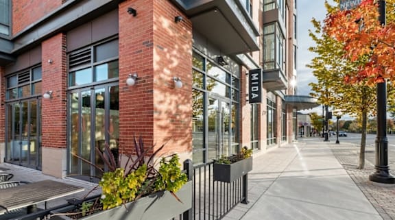 A street view of a building with the name  at Trio Newton Apartments, Newton