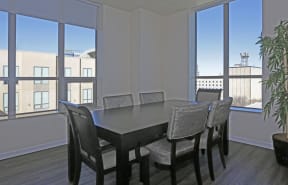 Downtown Sacramento CA Apartments for Rent - The Penthouses at Capitol Park - Furnished Dining Room With a Table and Six Chairs, Wooden Floors, and Large Windows