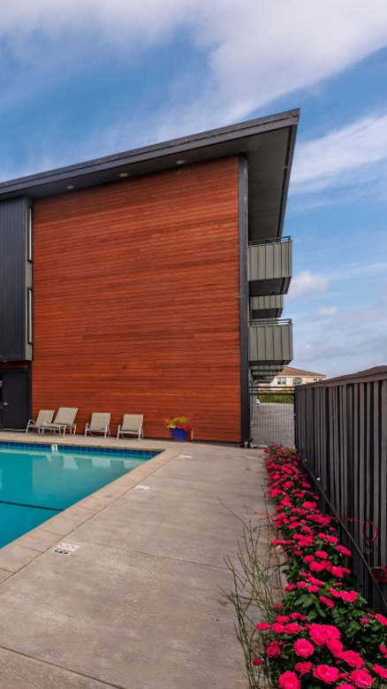 A swimming pool in front of a red brick building.