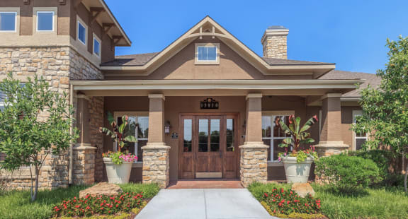 a home with a wooden door and stone pillars  at Stonepost Lakeside Apartments , Kansas , 66103