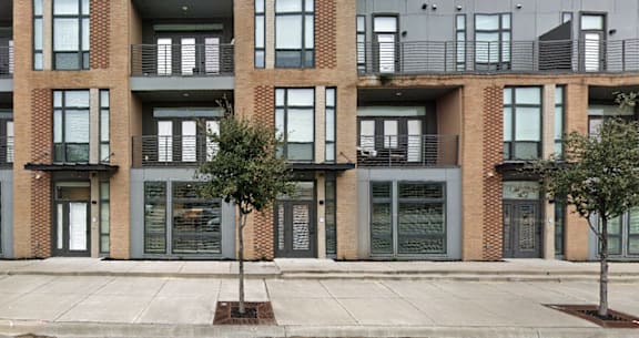 A building with a brick facade and a tree in front of it.