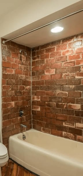 a bathroom with a white toilet next to a bathtub
