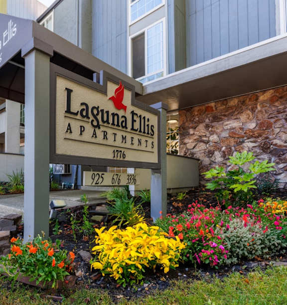 A sign for Laguna Ellis Apartments is displayed in front of a building.