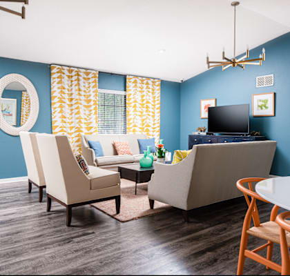 a living room with blue walls and a table and chairs at Sunscape Apartment Homes, Tampa, FL, 33613