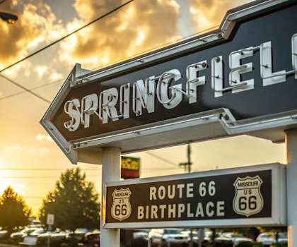 a sign for a parking lot with a sunset in the background
