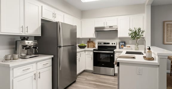 A kitchen with white cabinets and stainless steel appliances.