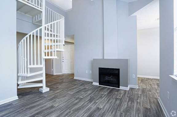 A white spiral staircase in a room with a fireplace.