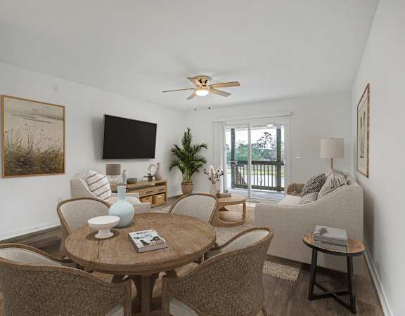 The Marley at Trout River Apartments in Jacksonville, FL 32218 a living room with a table and chairs and a ceiling fan