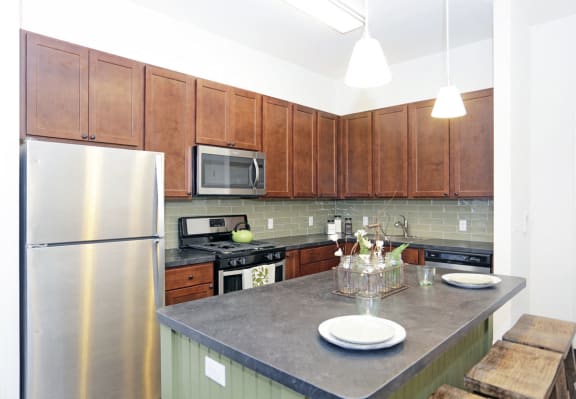 Kitchen with stainless steel appliances, wooden cabinets and breakfast bar