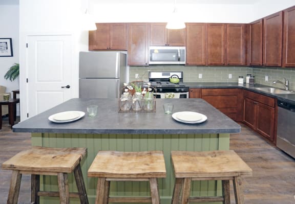 kitchen with stainless steel appliances, wooden cabinets, granite counter tops and breakfast bar
