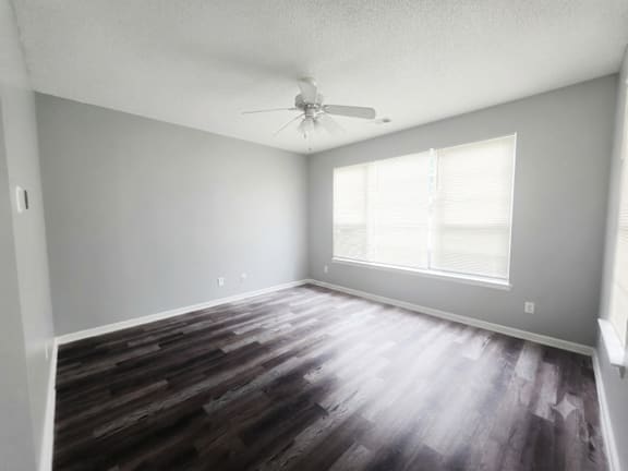 A room with a ceiling fan and a window.