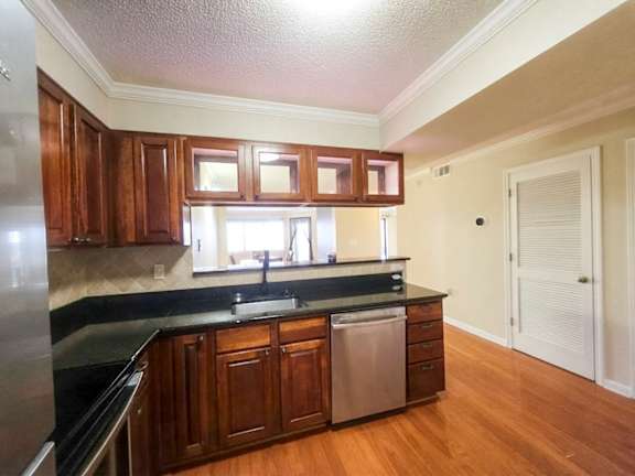 A kitchen with wooden cabinets and a black countertop.