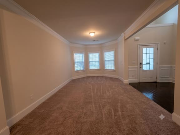 A room with a carpeted floor and a door.