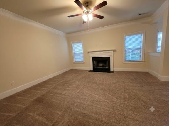 A room with a fireplace and a ceiling fan.